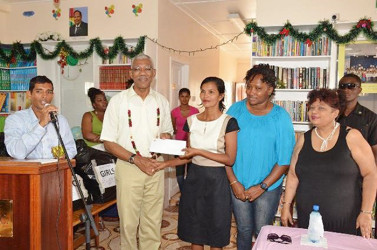 President David Granger (second from left) handing over a cheque for $2M to the Administrator of the Good Hope-Lusignan Learning Centre, Annette Roopchand while Ministers Annette Ferguson (second from right) and Amna Ally (right) look on. (Ministry of the Presidency photo)