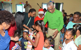 President David Granger distributing toys. (Ministry of the Presidency photo)