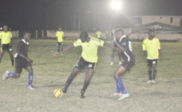 Clive Matthews of Grove Hi-Tech (centre) trying to maintain possession of the ball while being challenged by a Pouderoyen player during their team’s matchup at the Farm ground in the Stag Beer Super XVI Knockout Championships. 