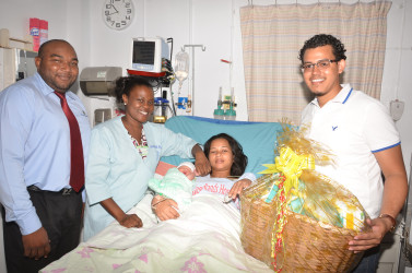 Camanie Kishon, gave birth to her first baby, a boy at Woodlands Hospital on Christmas Day. From left are ANSA Representative Joel Lee, nurse Omodelle Samuels and ANSA Representative Leon Fitzpatrick.        