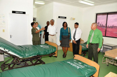 Savitri Chandrabose, Staff Nurse at the Leonora Diagnostic Centre (left) gestures while speaking to President David Granger (fourth from right), as Minister of Public Health, Dr George Norton (right)  and other officials listen during a guided tour of the old maternity wing of the hospital.  (Ministry of the Presidency photo) 