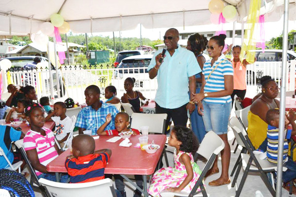 Minister Joseph Harmon and his daughter, Daniele interacting with the children (Ministry of the Presidency photo)