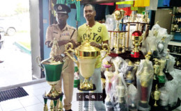 President of the Georgetown Football Association (GFA ) and Commander of `A’ Division of the Guyana Police Force Clifton Hicken and Ramesh Sunich of the Trophy Stall pose with the trophies at stake in the GFA Banks Beer Cup. All the trophies for the tournament have been donated by Sunich of the Trophy Stall, Bourda Market.