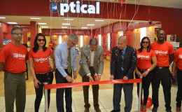 Managing Director of Courts Clyde de Haas is flanked by Minister of Business Dominic Gaskin and Minister of Public Health George Norton (at his right and left respectively) along with Courts staff as he cuts the ribbon for the opening of Courts Guyana’s optical department at its Main Street store.
