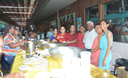 Sattaur Gafoor (third from right) and others sharing food at the event. 