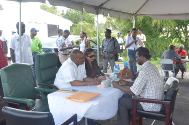 Minister of State Joseph Harmon (left) listening to one of the citizens.