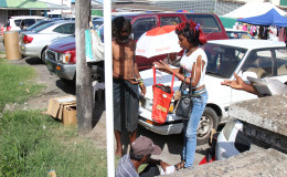 A young woman distributes Christmas packages to the homeless in front of Bourda Market 