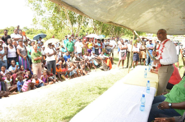 President David Granger speaking to residents of Baracara yesterday during his visit there. He spoke about self-sufficiency in the Canje community and also distributed gifts to children. (Ministry of the Presidency photo)