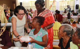 First Lady Sandra Granger (left) helping to share lunch. (Ministry of the Presidency photo)