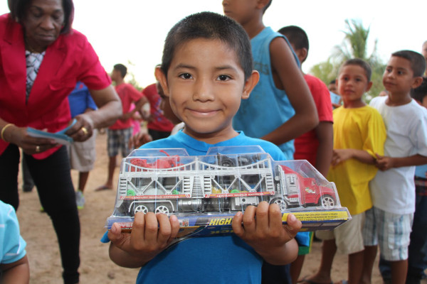 A St Ignatius boy beams as he displays his new toy truck. Minister of Social Cohesion, Amna Ally and  First Lady Sandra Granger yesterday distributed a large quantity of toys to children of St Ignatius, Rupununi. The visit was part of a distribution of bicycles to help ensure children get to school. (Ministry of the Presidency photo)