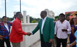 Former Prime Minister Sam Hinds (second from left) greeting Minister of State, Joseph Harmon at the launching of the Aruwai resort, Region Seven on Saturday. (Ministry of the Presidency photo)