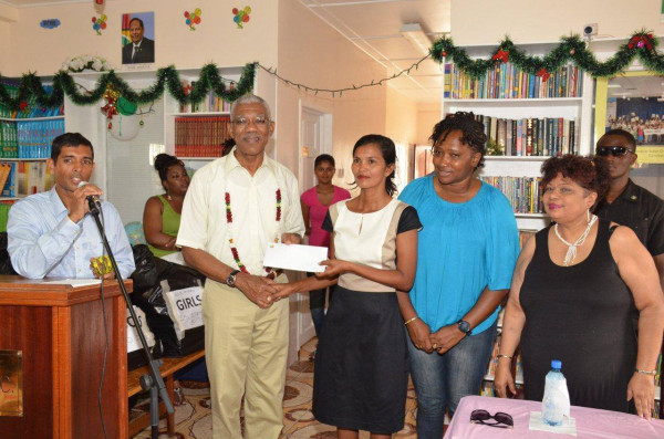 President David Granger (second from left) handing over a cheque for $2M to the Administrator of the Good Hope-Lusignan Learning Centre, Annette Roopchand while Ministers Annette Ferguson (second from right) and Amna Ally (right) look on. (Ministry of the Presidency photo)
