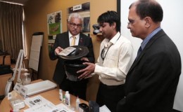 Health Minister Terrence Deyalsingh, left, holds a biological mosquito trap as entomologist Rajesh Ragoo, centre, explains how it works, while Chief Medical Officer Dr Clive Tilluckdharry looks on, during a media conference at the Ministry of Health, Park Street, Port-of-Spain, yesterday. 