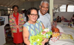 First Lady, Sandra Granger still has the touch.  She is pictured here holding a little girl born to Cassie Baksh of Herstelling on December 23, as President David Granger looks on.  (Ministry of the Presidency photo)