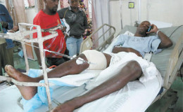 National senior footballer Keron Cummings speaks on his cell phone while warded at the Port-of-Spain General Hospital after being shot in the leg after returning home from a party on Saturday. Cummings was expected to join the national team in camp ahead of the Copa America Centenario match against Haiti on January 8