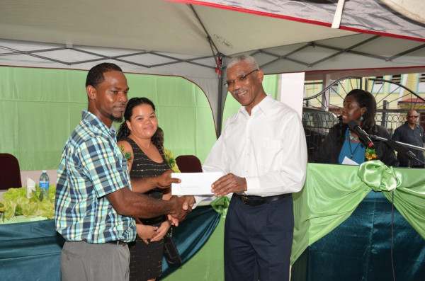 President David Granger (right) presents Ruella Waldron and Robert Gittens with their approval letter for a loan to expand their business.  The occasion was the launching yesterday of the Linden Enterprise Network’s (LEN)  micro credit programme at the newly refurbished Region 10 Business Centre. (Ministry of the Presidency photo)