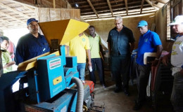 Minister of Agriculture Noel Holder (second from right) and other officials examine a rice milling machine during a visit to region 8 (GINA photo)