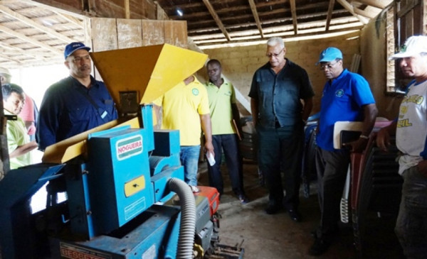 Minister of Agriculture Noel Holder (second from right) and other officials examine a rice milling machine during a visit to region 8 (GINA photo)