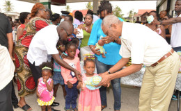 President David Granger (right) presenting toys to the children who assembled at Wilson Gas Station in Buxton Village. (Ministry of the Presidency photo)