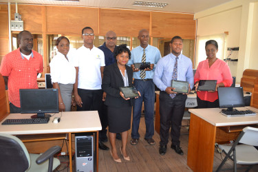 Generation Next Training Centre. Administrator Melissa McCullock (centre, front) and others display the tablets. Benefactor Karl Moore is directly behind McCullock 