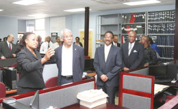Registrar of Commerce (ag) Nicole Prince (left) shows President David Granger some of the documents located in the Commercial Registry. Looking on are Attorney General Basil Williams (third from left) and Minister of State Joseph Harmon (fourth left). The Commercial Registry is located above the Land Registry in the former New Building Society (NBS) building on the Avenue of the Republic. (Keno George photo)