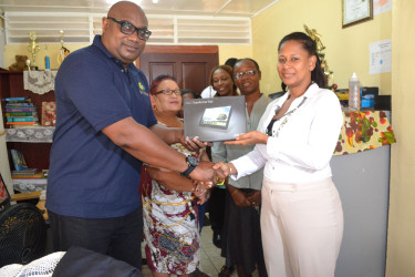  Drop-in-Centre Manager Melissa Gentle (right) receives one of the tablets from Karl Moore. 