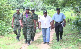 Ministers of Foreign Affairs, Carl Greenidge (second from right) and Guyana Defence Force Chief of Staff, Brigadier Mark Phillips (left in front row)  and other ranks of the force entering the village of Kaikan, Region Seven. (GINA photo)