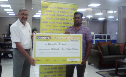 Courts Guyana’s Managing Director Clyde de Haas hands over the $2 million cheque to Danesh Persaud, the winner of Courts Guyana’s Big Money promotion  