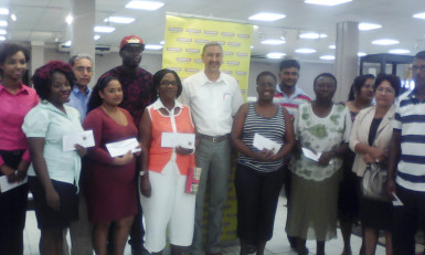 Courts Guyana’s Managing Director Clyde de Haas sharing a photo op with some of the Mabe promotion winners 