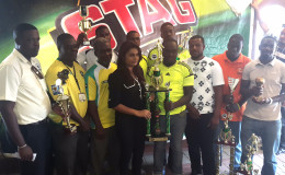 PRO of Ansa McAL Darshanie Yussuf presents the large championship trophy and cash prize to some club members of the Grove Hi Tech unit.