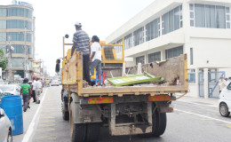 City council workers on Thursday along Robb Street with various signs that were collected during the exercise to seize signage placed on the road (Photo by Dhanash Ramroop)