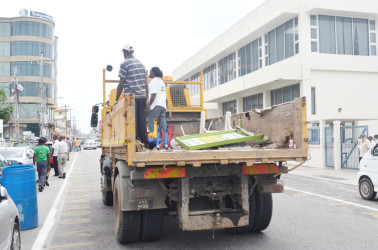 City council workers on Thursday along Robb Street with various signs that were collected during the exercise to seize signage placed on the road (Photo by Dhanash Ramroop)