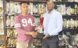Trophy Stall Chief Executive Officer Ramesh Sunich and GTTA president Godfrey Munroe with one of the trophies.