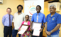  Winners of the THAG essay competition Victoryne Mohabir and Omari Obaseki Joseph (at centre) flanked by competition judges Dr. Steve Surujbally (at right) and Ruel Johnson (second left) along with President of THAG Shaun McGrath (extreme left)