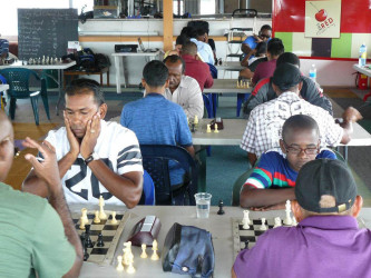 President of the Guyana Chess Federation Irshad Mohammed (left) concentrates as he plays a game of chess. Mohammed was elected President in February 2014.