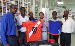  Arron Fraser of Medicine Chest (centre) handing over the kits and uniforms to members of the Fruta Conquerors executive and coaching staff while GFF Technical Development Officer (TDO) Lyndon France looks on.