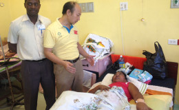 GPHC’s Dr. Kurtly Hestick (left) looks on as Dr Wang interacts with a recovering Deepan in the female ward of the hospital.