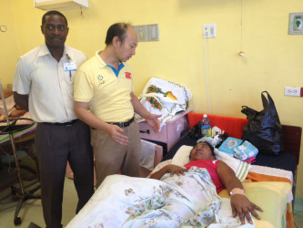 GPHC’s Dr. Kurtly Hestick (left) looks on as Dr Wang interacts with a recovering Deepan in the female ward of the hospital.  