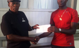 Coach of the Flying Ace Cycle Club and event organizer, Randolph Roberts (left) receives the sponsorship package from CEO of the Benjamin’s Sports Store, Wilbert Benjamin.