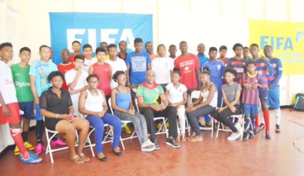 GFF Head of Referees Stanley Lancaster (centre) posing with students from the various schools in the fourth annual Milo U20 Football Championship during the GFF/Petra Organization Grassroots Referees Clinic at the Ministry of Education ground on Carifesta Avenue.