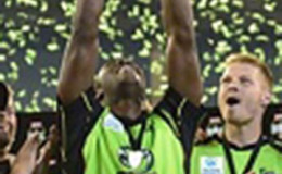 West Indies star Andre Russell holds the Big Bash title aloft after Sydney Thunder captured the men’s final yesterday.