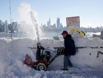 A resident removes snow away from the entrance to his home in Union City, New Jersey, across the Hudson River from Midtown Manhattan, after the second-biggest winter storm in New York history, January 24, 2016. REUTERS/Rickey Rogers