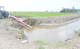 A farmer pumping water from the visibly low canal onto his land.
