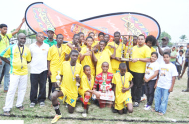 Victorious Grove Hi-Tech Captain Denzil Crawford collects the championship trophy from Marketing and Sales Manager of Continental Agencies Limited Avalon Jagnandan (third from right) while other members of the team and officials look on.