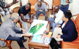 Minister of Education Dr Rupert Roopnaraine (left) and Alex Bunbury (second from left) discussing the academy plan. (Ministry of Education photo)