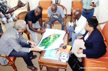 Minister of Education Dr Rupert Roopnaraine (left) and Alex Bunbury (second from left) discussing the academy plan. (Ministry of Education photo)