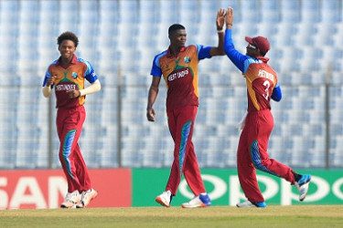 Fast bowler Alzarri Joseph (centre) celebrates a wicket with captain Shimron Hetmyer (right) during Friday’s encounter against England. (Photo courtesy ICC) 