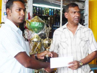Flashback to 2010: Tournament Director of the Guyana Chess Federation and currently its President, Irshad Mohammed, is seen here at left receiving the cash and trophies from owner of the Trophy Stall Ramesh Sunich in 2010. Since chess restarted its engines in 2007, Sunich has been a principal supporter of the elegant brain game. The Trophy Stall chess tournament for 2016 continues today from 9.30 am at the National Racquet Centre in Woolford Avenue opposite the Government Technical Institute