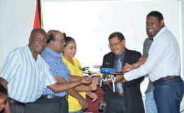 Minister of Indigenous Peoples’ Affairs Sydney Allicock (second from right) receives the drone from Dr. Anthony Cummings (right). Representatives from the Ministry of Agriculture are also in photo (GINA photo)
