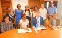 Ambassador Jernej Videtič and Omattie Madray affix their signatures to the contract in the presence of EU Delegation and Childlink Inc officials.